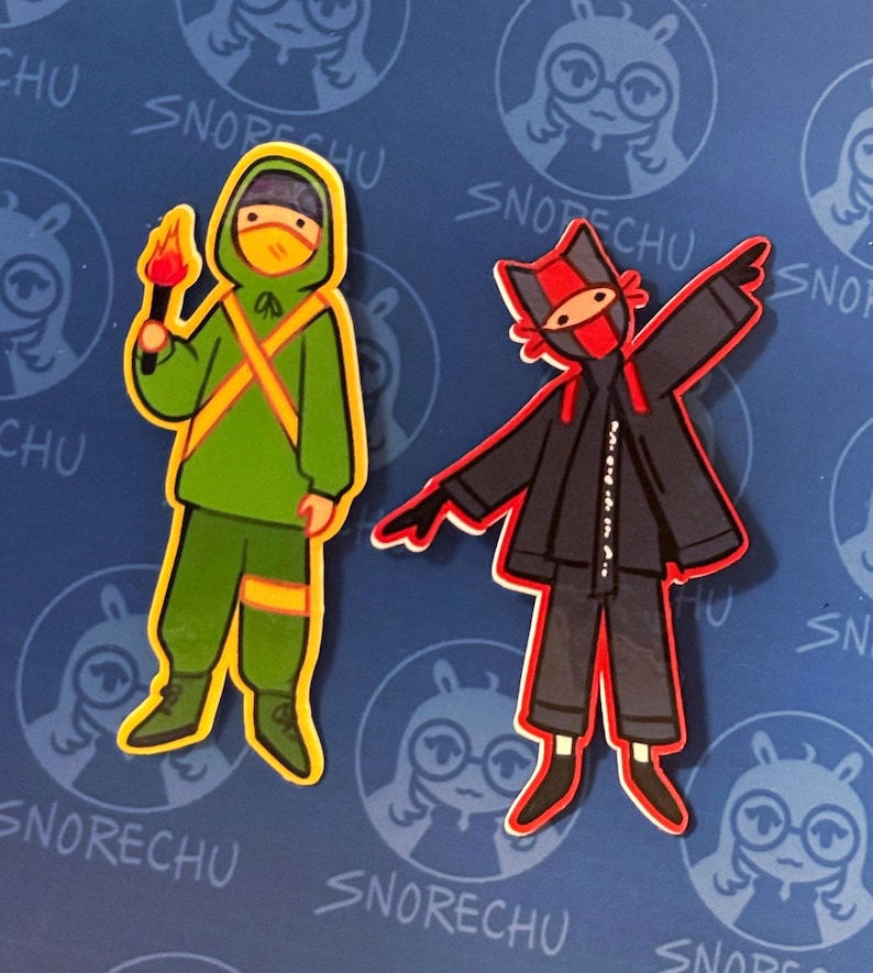 May include: Two sticker designs featuring cartoon figures. One figure is in a green hooded outfit with a yellow outline, holding a torch. The other figure is in a black outfit with a red mask and accents. The background is blue with a repeating logo.