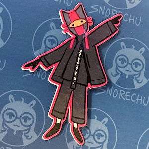 May include: A sticker featuring a cartoon character in a ninja-like outfit. The character has a cat-like head with a red and black mask, a black outfit with a red outline, and is posed with one arm raised. The background is blue with a repeating pattern.