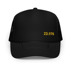 May include: Black trucker hat with a black mesh back and a gold embroidered number "23.976" on the front.