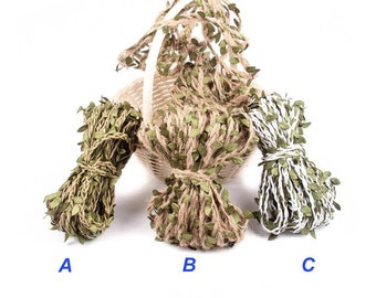 Puede incluir: Tres carretes de cuerda con hojas verdes tejidas en la cuerda. La cuerda es marrón, blanca y verde. Los carretes están etiquetados con A, B y C.