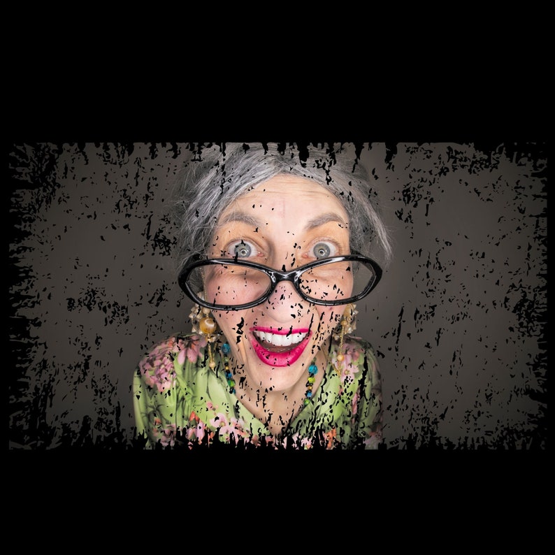 May include: A woman with grey hair and a surprised expression wears black-rimmed glasses and a green floral print blouse.