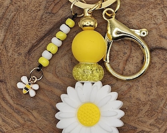 Llavero de flor de margarita con dije de abeja