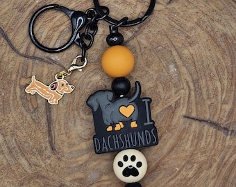 Llavero "Me encantan los perros salchicha": llavero de perro salchicha o salchicha con cuenta en forma de pata, color naranja y negro, ideal para amantes de los perros.