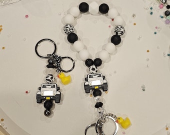 Llavero de silicona con cuentas y dije de pato, con forma de camión todoterreno, color blanco.