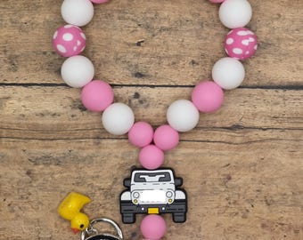 Pulsera o llavero colgante de silicona con cuentas de camión todoterreno 4x4 y dije de pato en rosa y blanco.