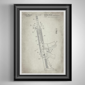 May include: A framed U.S. Patent print for the McMillan TAC-50 firearm, dated Oct. 22, 2013. The document features a detailed technical line drawing labeled FIG. 1, showing the rifle with numbered components on a vintage-style beige background.