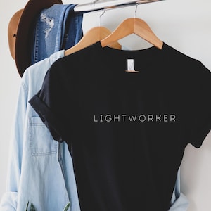 May include: Black t-shirt with the text "LIGHTWORKER" printed in white on the front.