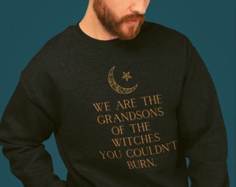 Może przedstawiać: Czarna bluza z nadrukiem złotego półksiężyca i gwiazdy. Na przodzie znajduje się napis "We are the grandsons of the witches you couldn't burn."