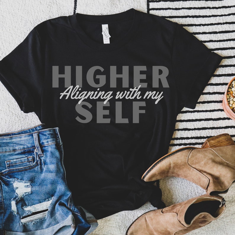 May include: Black t-shirt with the text "HIGHER Aligning with my SELF" in gray lettering.