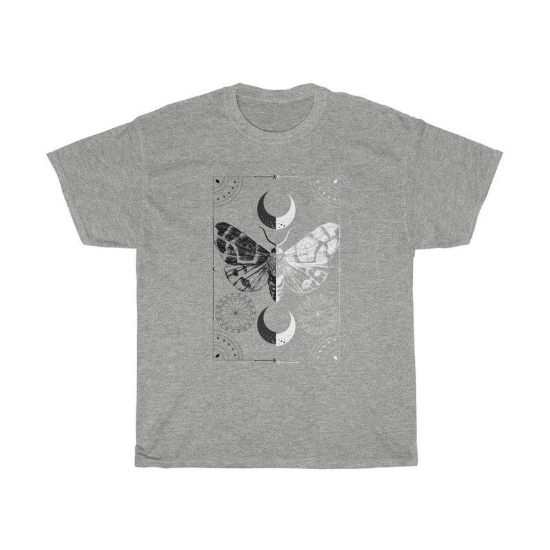 K&ouml;nnte beinhalten: Ein graues T-Shirt mit einem schwarzen und wei&szlig;en Mottiv. Die Motte ist von einem geometrischen Muster und Halbmonden umgeben.