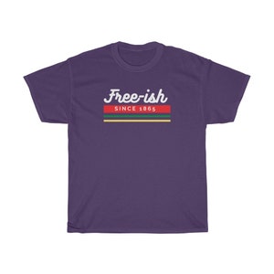 May include: A purple t-shirt with the text "Free-ish" in white script above a horizontal stripe design. The stripe design includes red, green, and yellow bands, with the text "SINCE 1865" below the script.