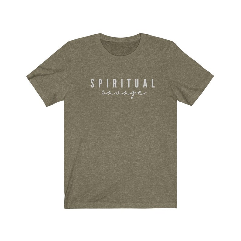 May include: Olive green t-shirt with the words "SPIRITUAL savage" printed in white. The top text is in a sans-serif font, and the bottom word is in a cursive font. The shirt has short sleeves and a crew neck.