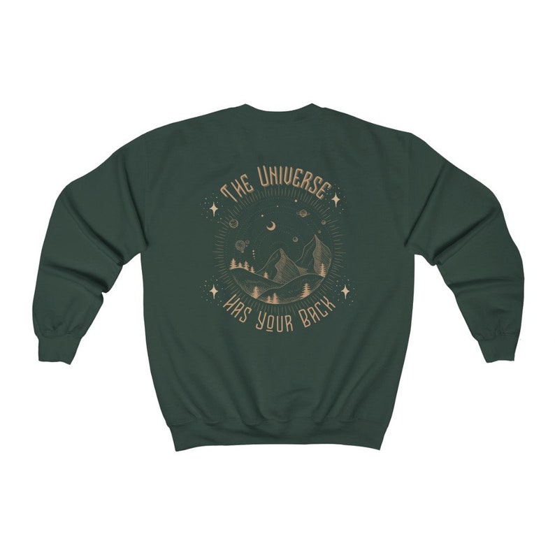 May include: A dark green sweatshirt with a graphic print on the back. The graphic features a mountain range, a crescent moon, stars, and the text "The Universe Has Your Back".