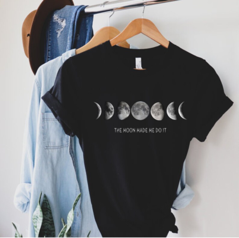 May include: Black t-shirt with a graphic of the moon phases and the text "The Moon Made Me Do It."