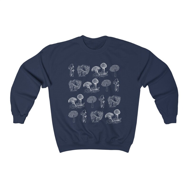 May include: Navy blue sweatshirt with a white mushroom graphic print. The mushrooms are arranged in a repeating pattern across the front of the sweatshirt.