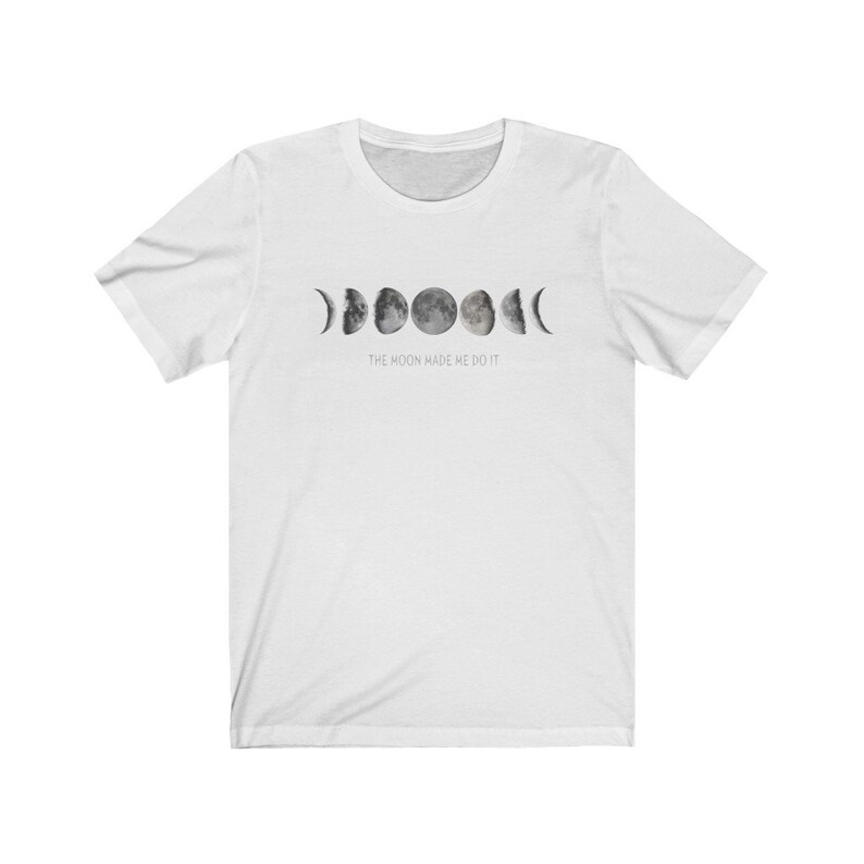 May include: White t-shirt with a graphic of the moon phases and the text "The moon made me do it."