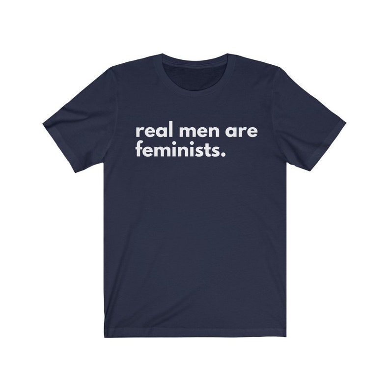 May include: Navy blue t-shirt with white text that reads "real men are feminists."