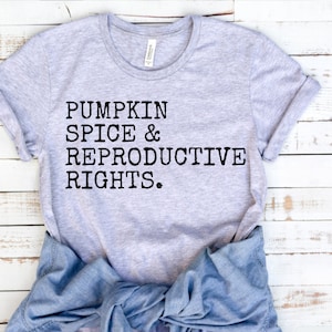 May include: A grey t-shirt with the text "Pumpkin Spice & Reproductive Rights." printed in black.