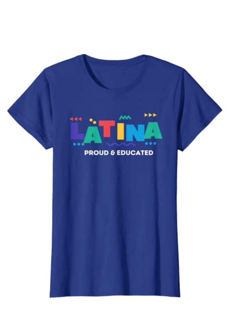 May include: A royal blue t-shirt with the word "LATINA" in colorful, geometric letters. Below the word is the phrase "PROUD & EDUCATED" in white. The shirt is a classic crew neck style.