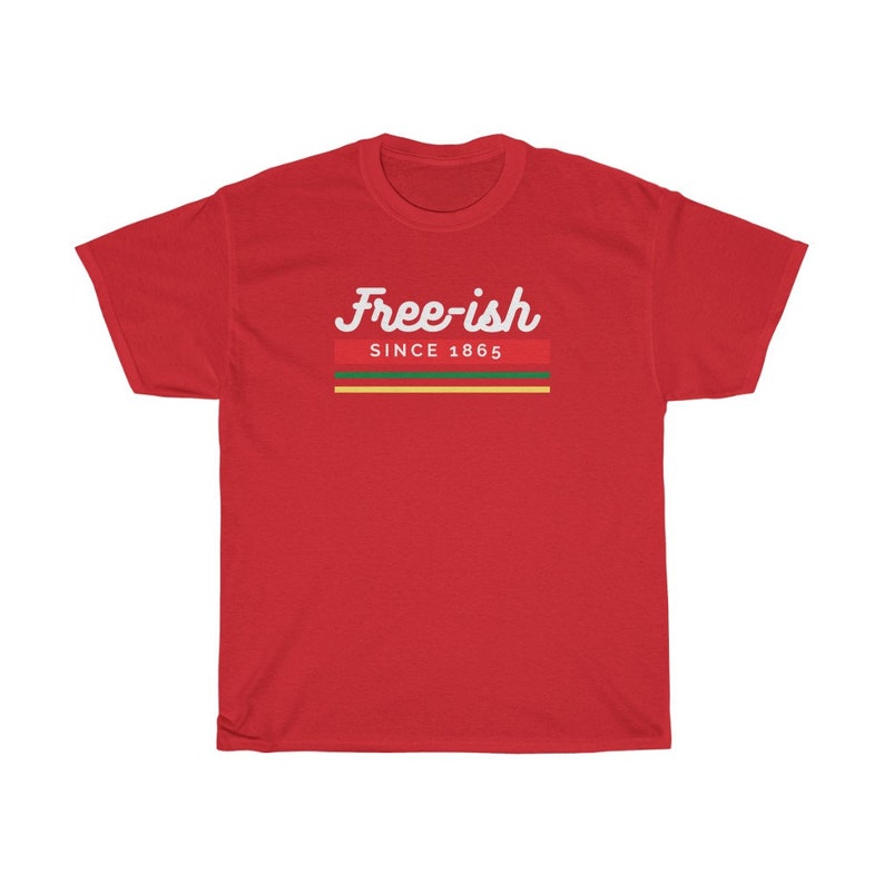May include: A red t-shirt with the words "Free-ish" in white script above a horizontal stripe design in red, green, and yellow, with "SINCE 1865" below. The shirt is made of a soft material.
