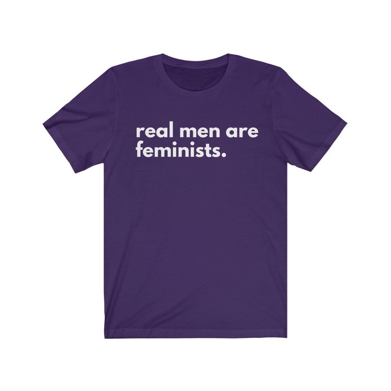 May include: Purple short-sleeved t-shirt with white text that reads "real men are feminists."