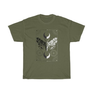 K&ouml;nnte beinhalten: Ein gr&uuml;nes T-Shirt mit einem schwarzen und wei&szlig;en Motten-Motiv. Die Motte ist von einem geometrischen Design mit Halbmonden umgeben.