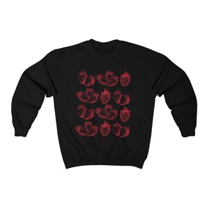 May include: Black sweatshirt with a red outline of strawberries printed on the front.