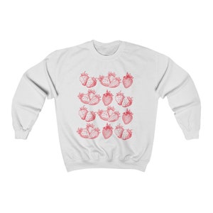 May include: White sweatshirt with a red strawberry print pattern. The strawberries are arranged in rows and are a vintage style illustration.