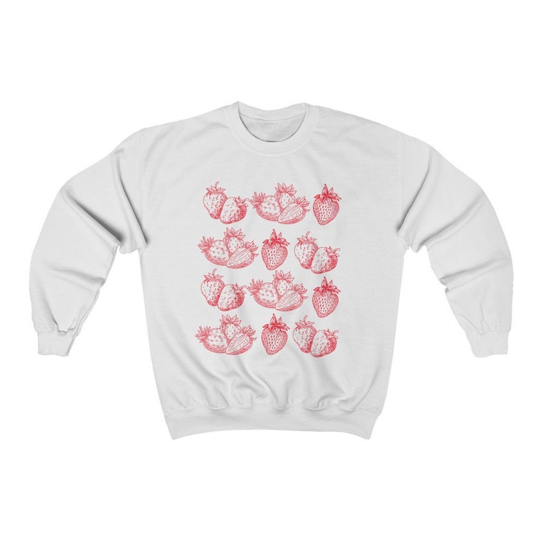 May include: White sweatshirt with a red strawberry print pattern. The strawberries are arranged in rows and are a vintage style illustration.