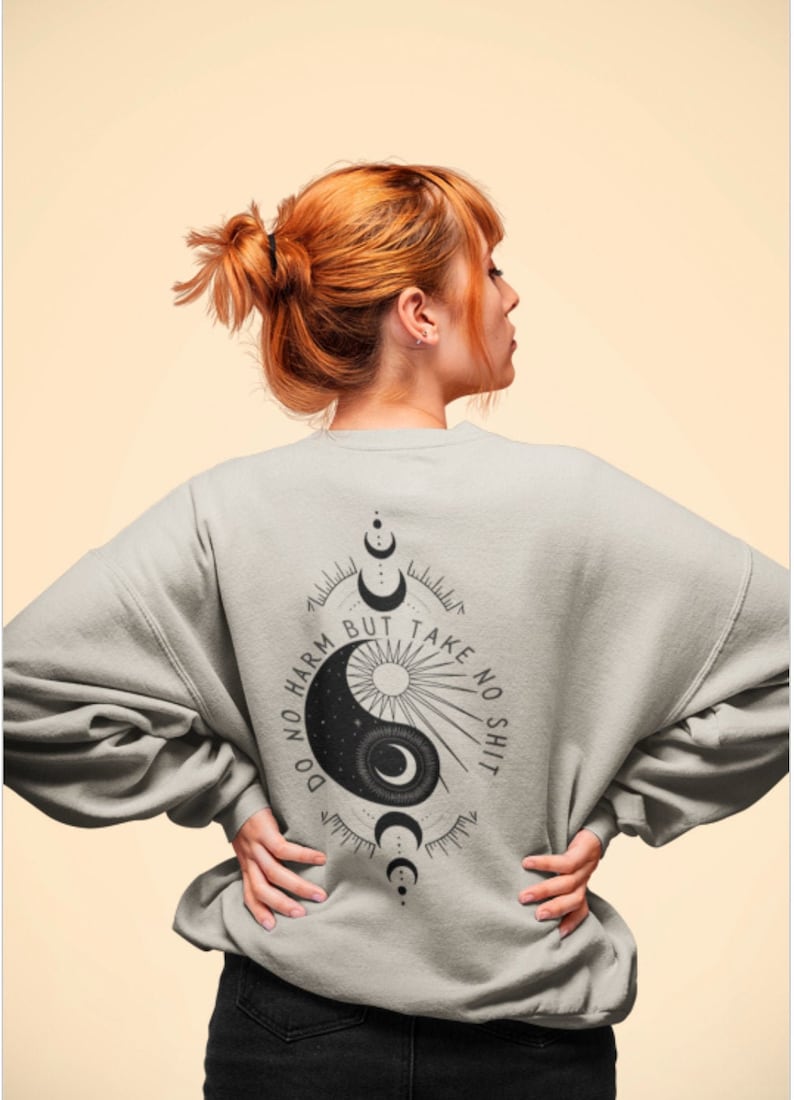 May include: A gray sweatshirt with a black yin yang symbol and the text "Do no harm but take no shit" printed on the back.