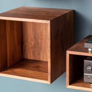 May include: Two wooden wall shelves, one with a record player and a stereo receiver, the other empty.