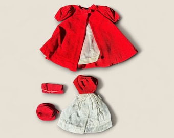 May include: A red velvet doll dress with a white lining, a red velvet hat, and a red velvet doll dress with a white skirt.