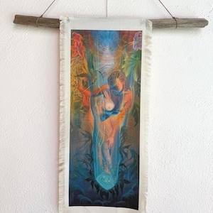 May include: A rectangular wall hanging with a colourful illustration of two figures embracing, surrounded by lush foliage. The artwork features vibrant blues, oranges, and greens, with a fringed bottom edge. It is suspended from a natural wooden rod by a string.
