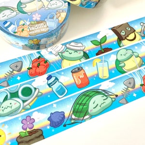 May include: Two rolls of blue and white washi tape with a repeating pattern of turtles, clouds, and various items related to recycling. The text on the tape reads "Reduce Reuse Recycle" and "Itsdiful washi tape".