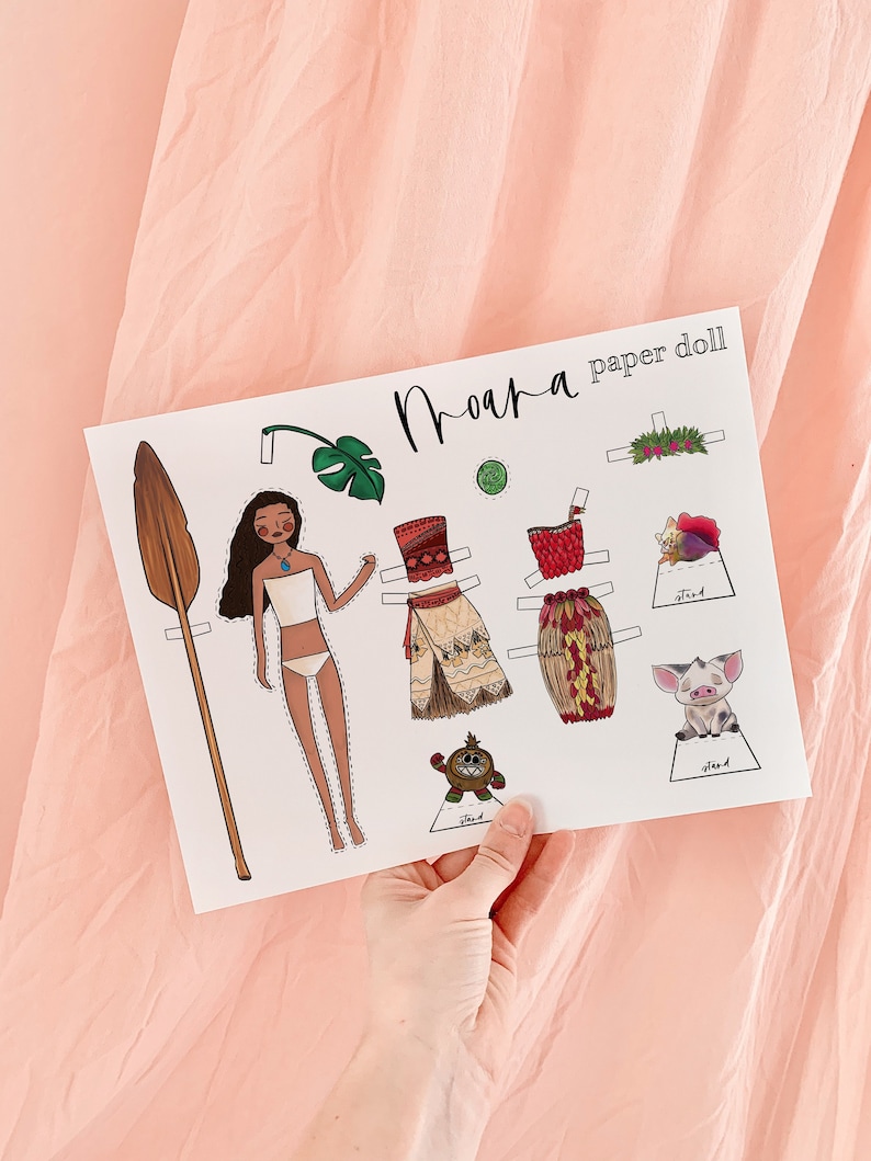 May include: A printable paper doll set featuring Moana from the Disney movie Moana. The set includes Moana's body, a paddle, a flower crown, a green leaf, a red and brown skirt, a red and brown top, a brown and white skirt, a brown and white top, a pig, and a monkey.