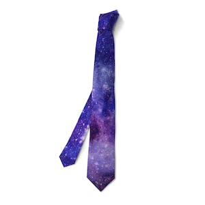 May include: A purple and blue tie with a galaxy print. The tie has a white background with a scattering of stars and nebulae.