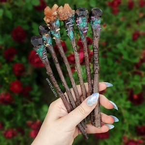 May include: A set of six wooden wands with crystal tops. The wands are brown and have intricate carvings. The crystals are various shades of orange and brown.