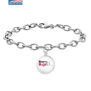 Op de afbeelding: Een zilverkleurige armband met een ovale schakelketting en een ronde bedel. De bedel toont de woorden "Maserati Bugatti..." in zwarte en rode tekst op een witte achtergrond. De armband heeft een karabijnsluiting.