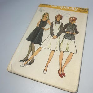 May include: Simplicity sewing pattern #8100 for three dresses. The pattern includes a black dress, a white dress with a plaid top, and a white dress with a plaid shirt. The pattern is for sizes 8-18.