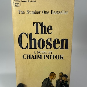 May include: Vintage paperback book titled "The Chosen" by Chaim Potok. The cover is a light tan color with black text and an illustration of three men. The book is a Fawcett Crest Book.