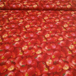 May include: Red fabric with a repeating pattern of red apples. The apples are arranged in a close-up, overlapping pattern.