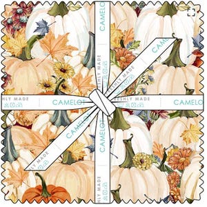 Peut inclure: Une pile carrée de carrés de tissu attachés avec un ruban blanc portant le texte CAMELOT FRESHLY MADE. Le tissu présente un motif de citrouilles blanches, de citrouilles orange, de feuilles d'automne jaunes et orange et de petites fleurs jaunes.
