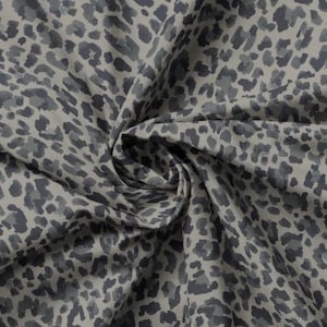 Peut inclure: Gros plan sur un tissu avec un motif répété de taches de léopard grises et gris foncé sur un fond gris clair. Le tissu est froissé et plié, montrant la texture et le drapé du matériau.