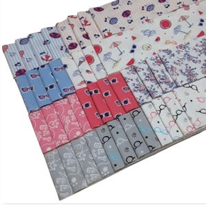 Peut inclure: Un ensemble de carrés de tissu avec différents motifs sur le thème de l'été. Les motifs comprennent des lunettes de soleil, des pastèques, des parapluies et des empreintes de pattes. Les tissus sont dans des tons de rose, bleu, blanc et gris.