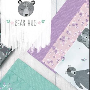 Peut inclure: Une collection d'échantillons de tissu comprenant un panneau blanc avec une illustration d'ours gris et le texte BEAR HUG, un tissu violet texturé, un tissu rose clair à motifs floraux violets et un tissu sarcelle à motif géométrique pointillé.