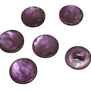 May include: Six purple iridescent buttons with a two-hole design. The buttons are round and have a smooth, shiny finish.