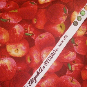 May include: Red apple fabric with a white label that reads "Elizabeth's Studio Inc. Patt # 260".