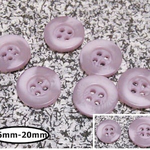 May include: Six purple and white swirl buttons with four holes each. The buttons are 16mm to 20mm in size.