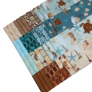 Peut inclure: Un assortiment de carrés de tissu aux motifs et couleurs variés. Les motifs incluent des tortues, des hippocampes et des formes géométriques dans des tons de bleu, marron et beige. Certains carrés comportent du texte. Idéal pour le patchwork ou les projets de couture.