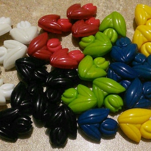 Peut inclure: Assortiment de boutons en plastique en forme de fleur de différentes couleurs, dont le rouge, le blanc, le noir, le vert, le bleu et le jaune.
